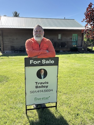 Travis Bailey in front of a home